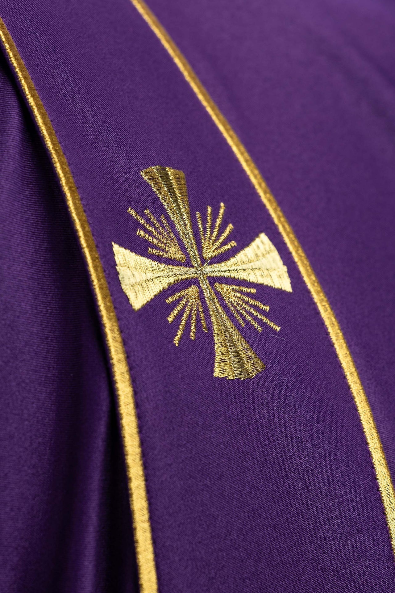 Dalmática morada con bandas y cruces doradas bordadas