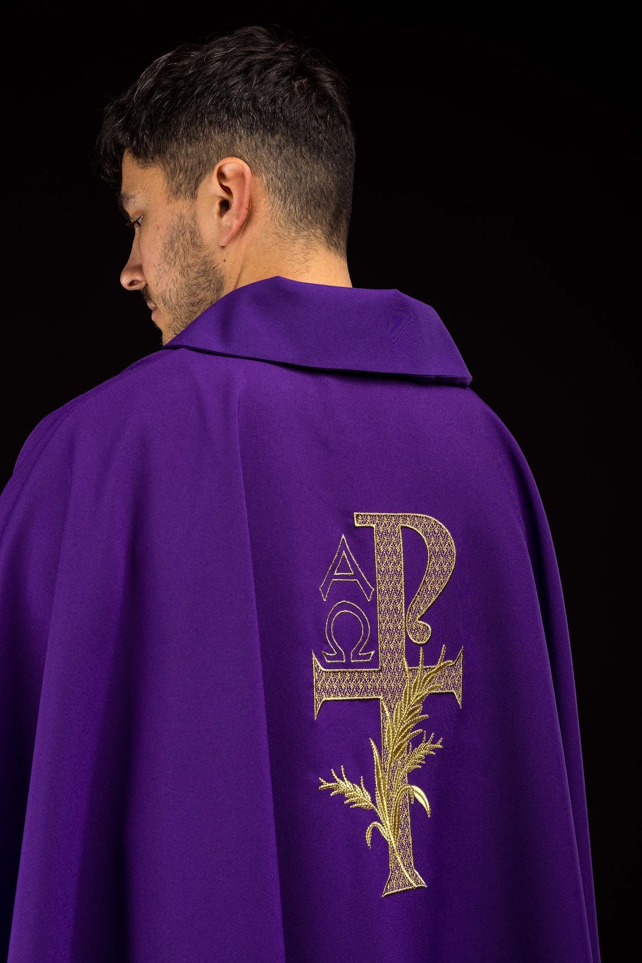 Casulla bordada con el símbolo Alfa y Omega y cuello ancho en color morado