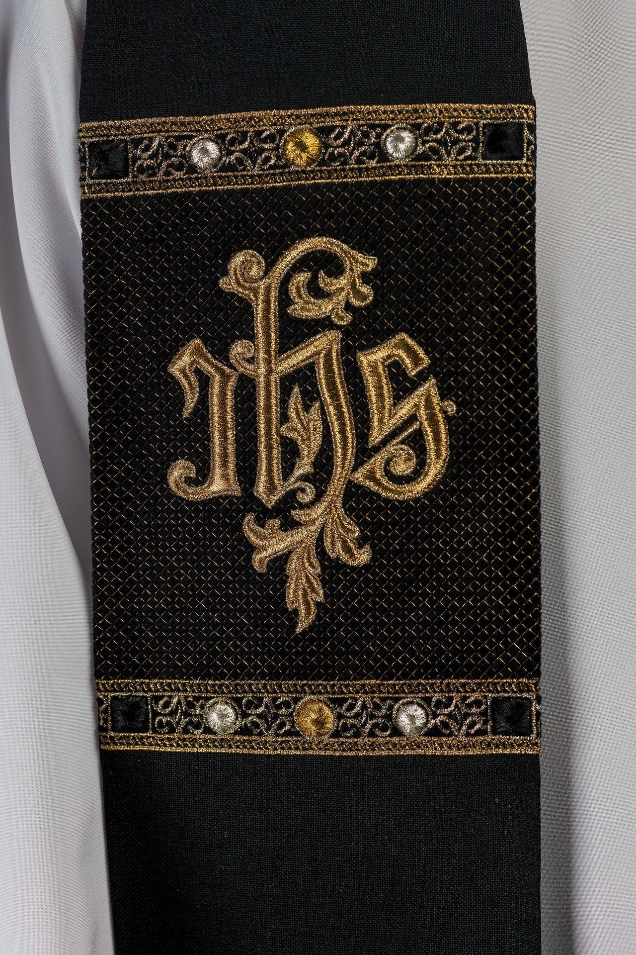 Estola bordada con motivo IHS en color negro