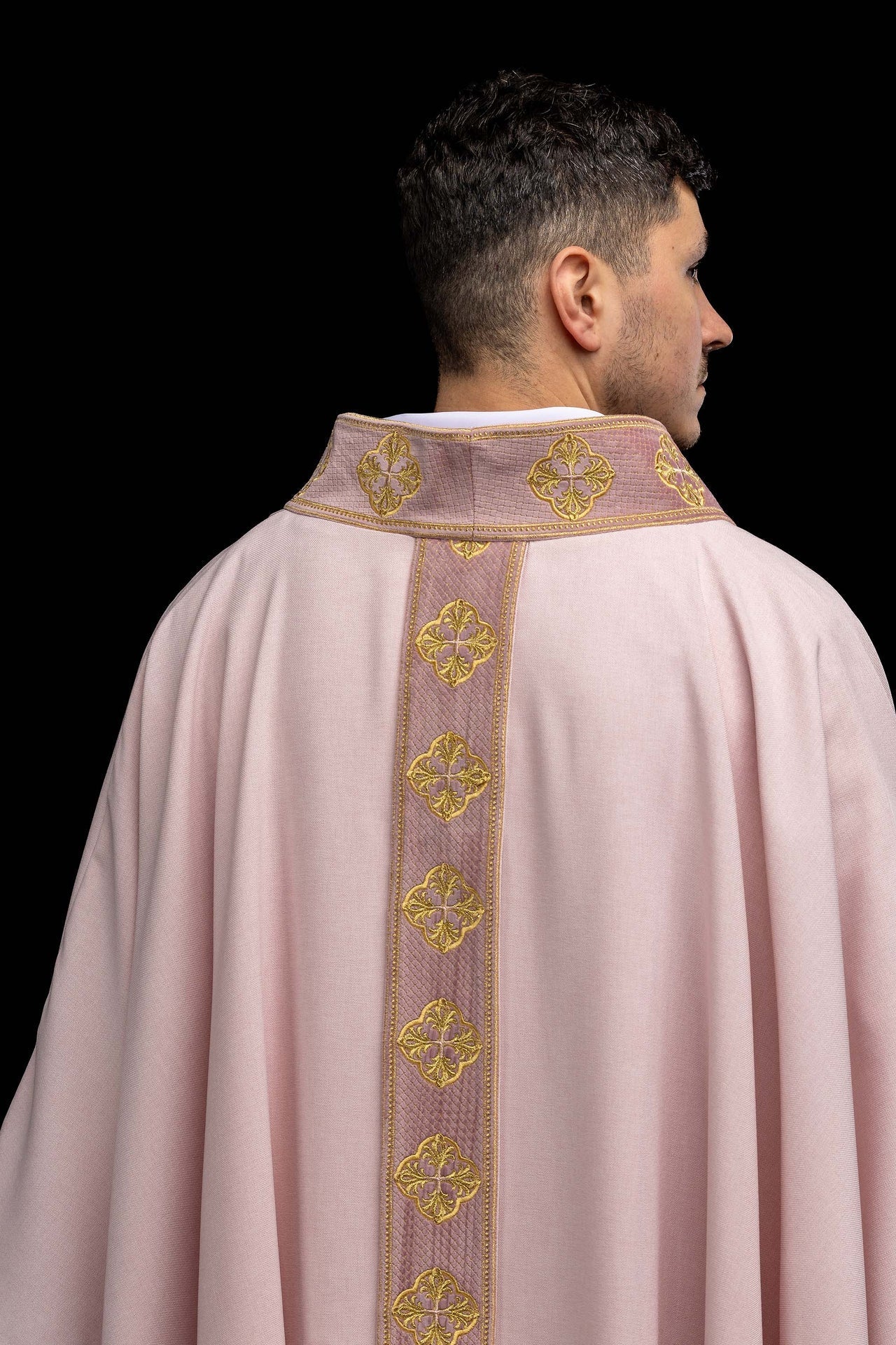Casulla de color rosa con banda bordada y cuello con cruces