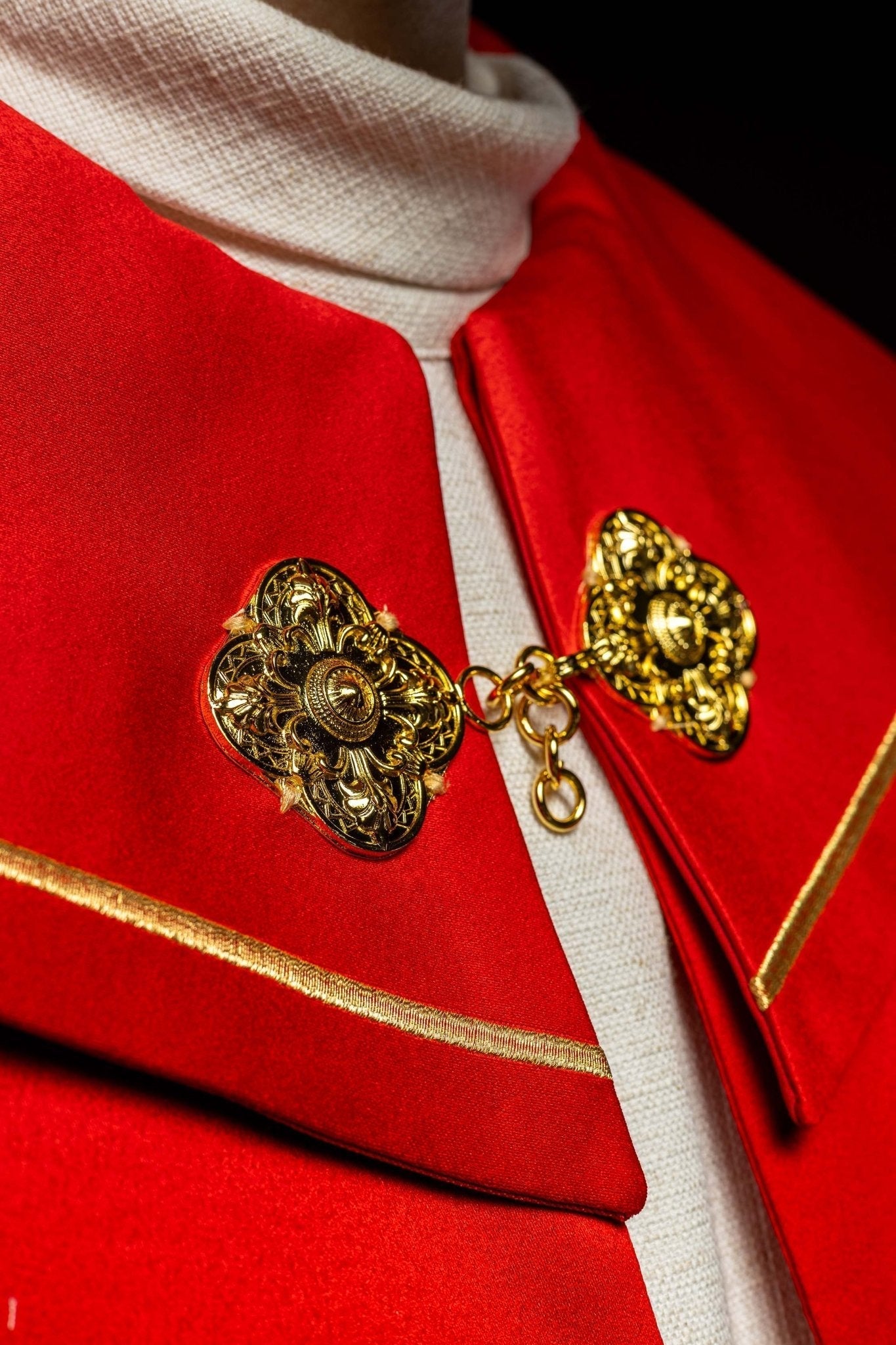 Capa pluvial roja con bordado cruces con picos
