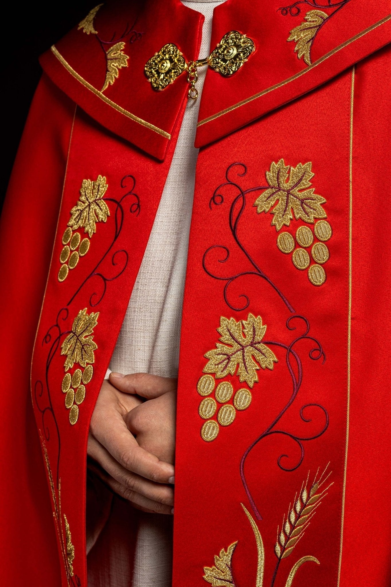 Capa pluvial roja con IHS dorado y bordado uvas