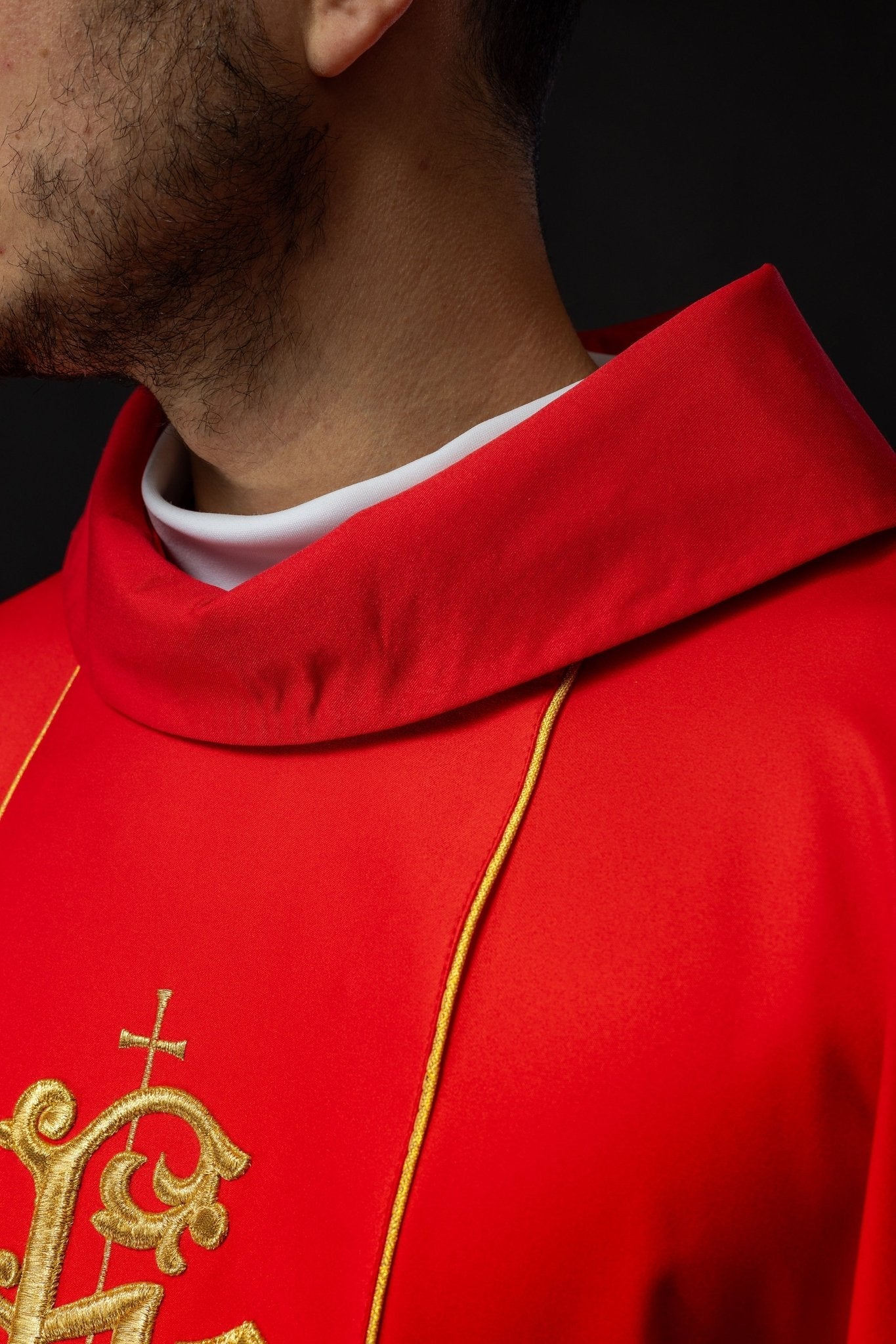 Casulla litúrgica roja con cinturón ricamente decorado con motivos florales e IHS