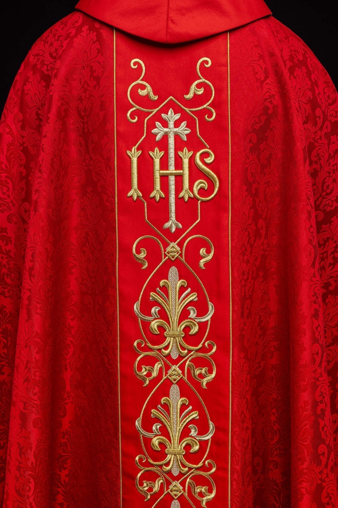 Casulla roja con bordado IHS ; la tela decorativa
