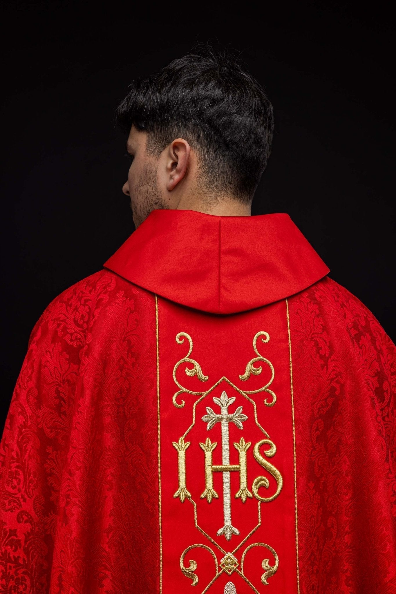 Casulla roja con bordado IHS ; la tela decorativa