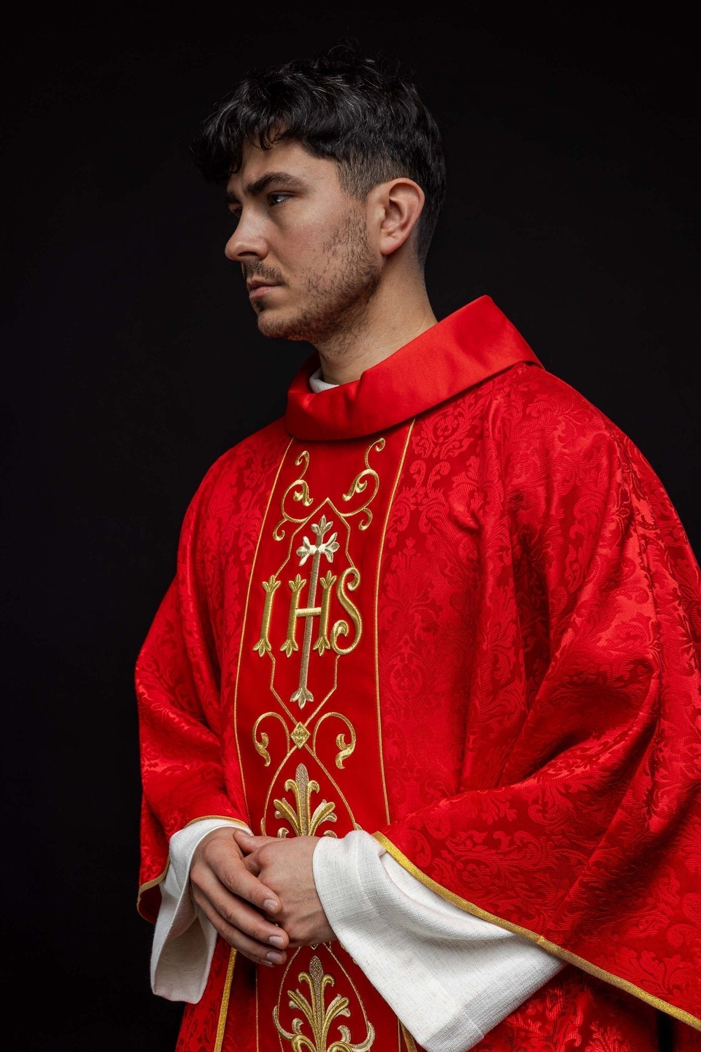 Casulla roja con bordado IHS ; la tela decorativa