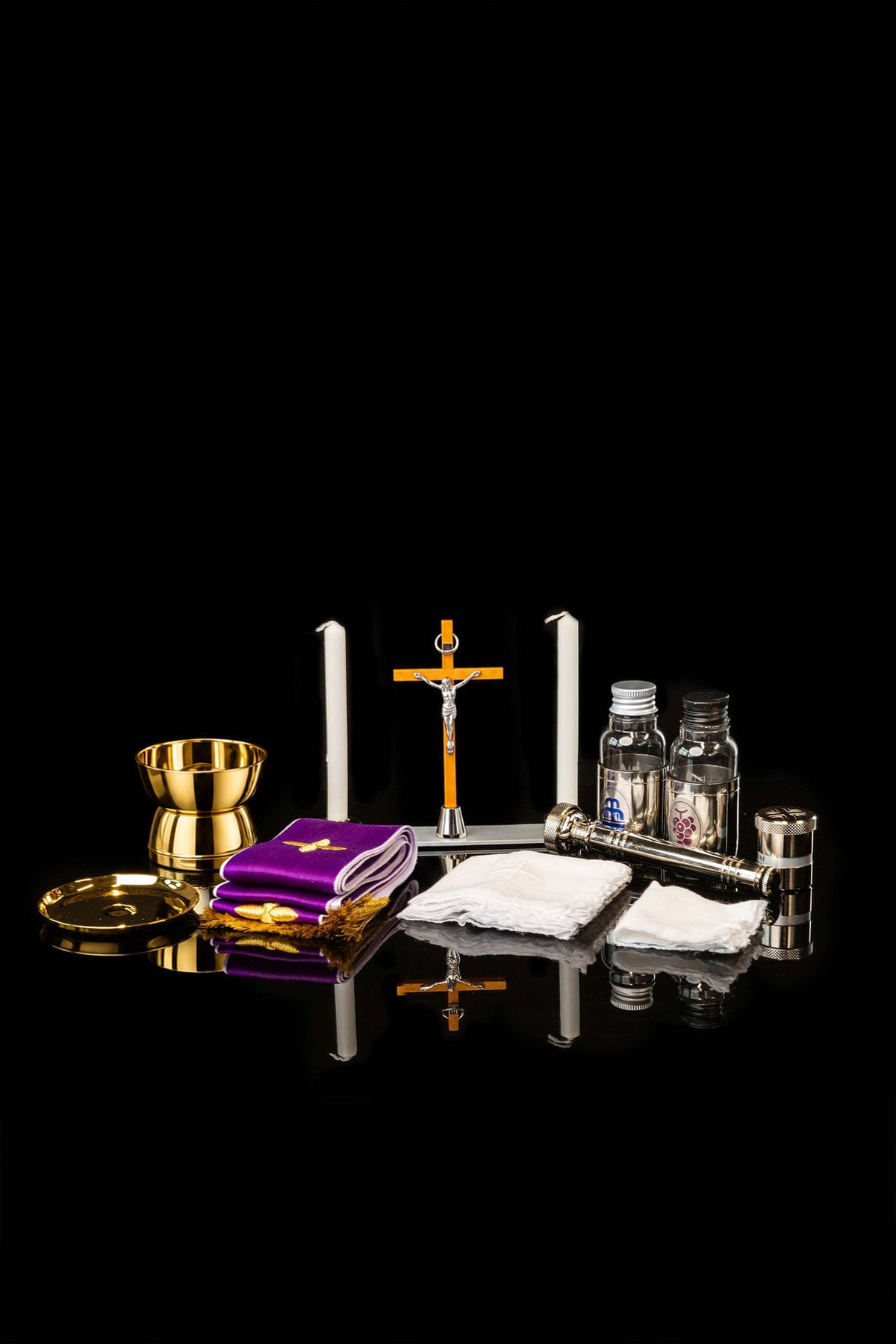 Maleta litúrgica abierta con cáliz, crucifijo, velas, purificador y textiles