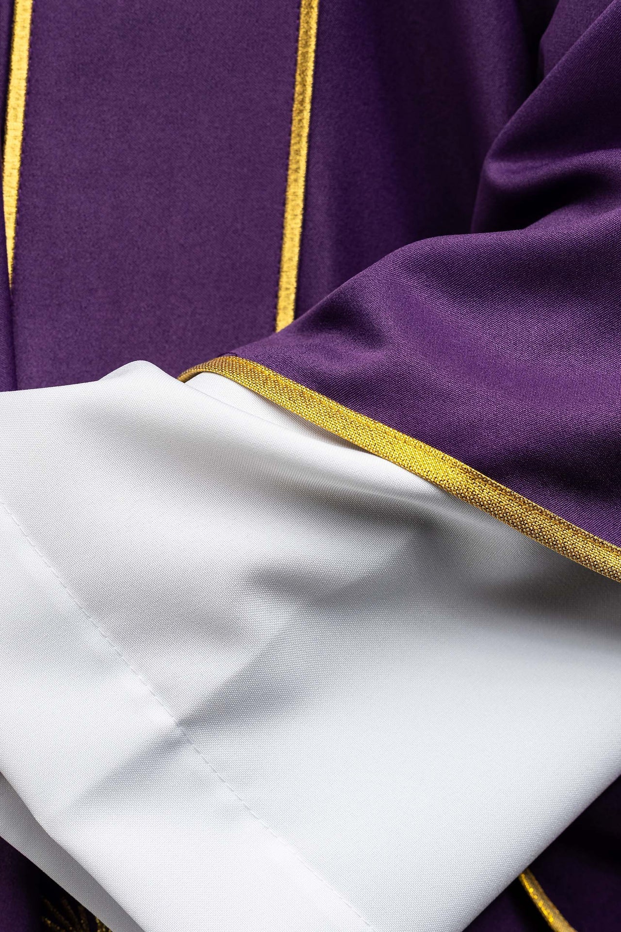Dalmática morada con bandas y cruces doradas bordadas
