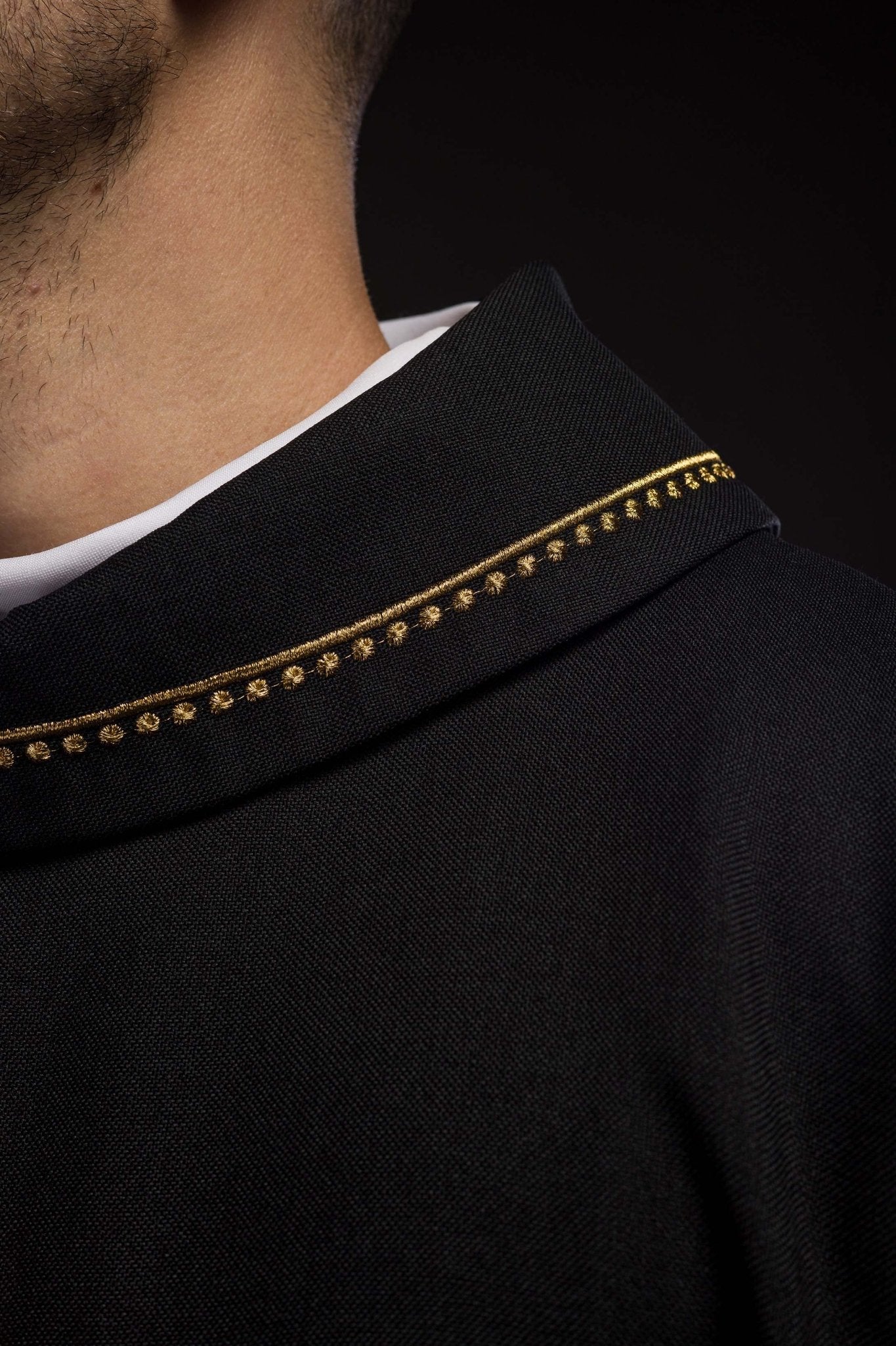Casulla con cruz bordada y ribete dorado en el cuello y de color negro