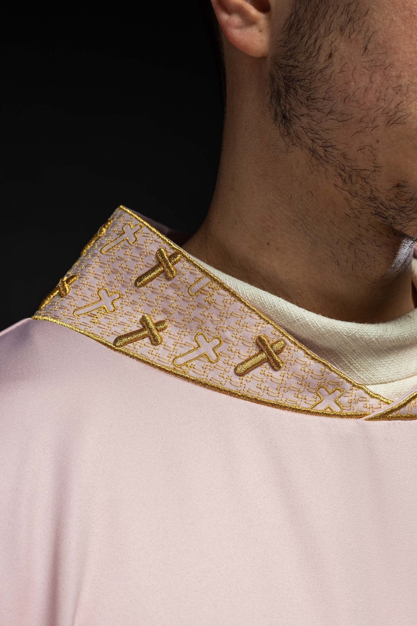 Casulla con una cruz ricamente bordada y cuello rosa