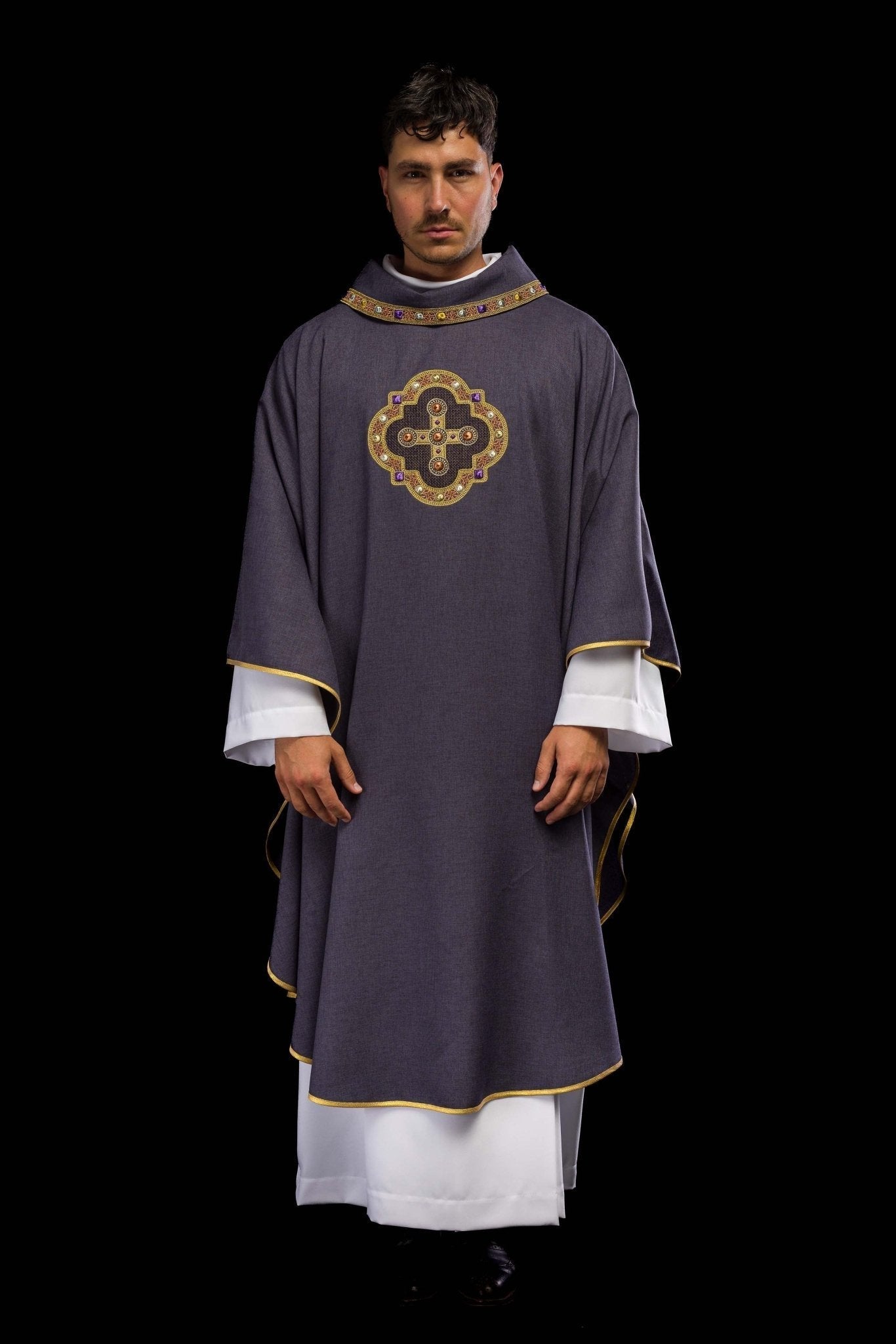 Casulla de color morado con ribetes bordados en el cuello y alrededor del bordado de la cruz.