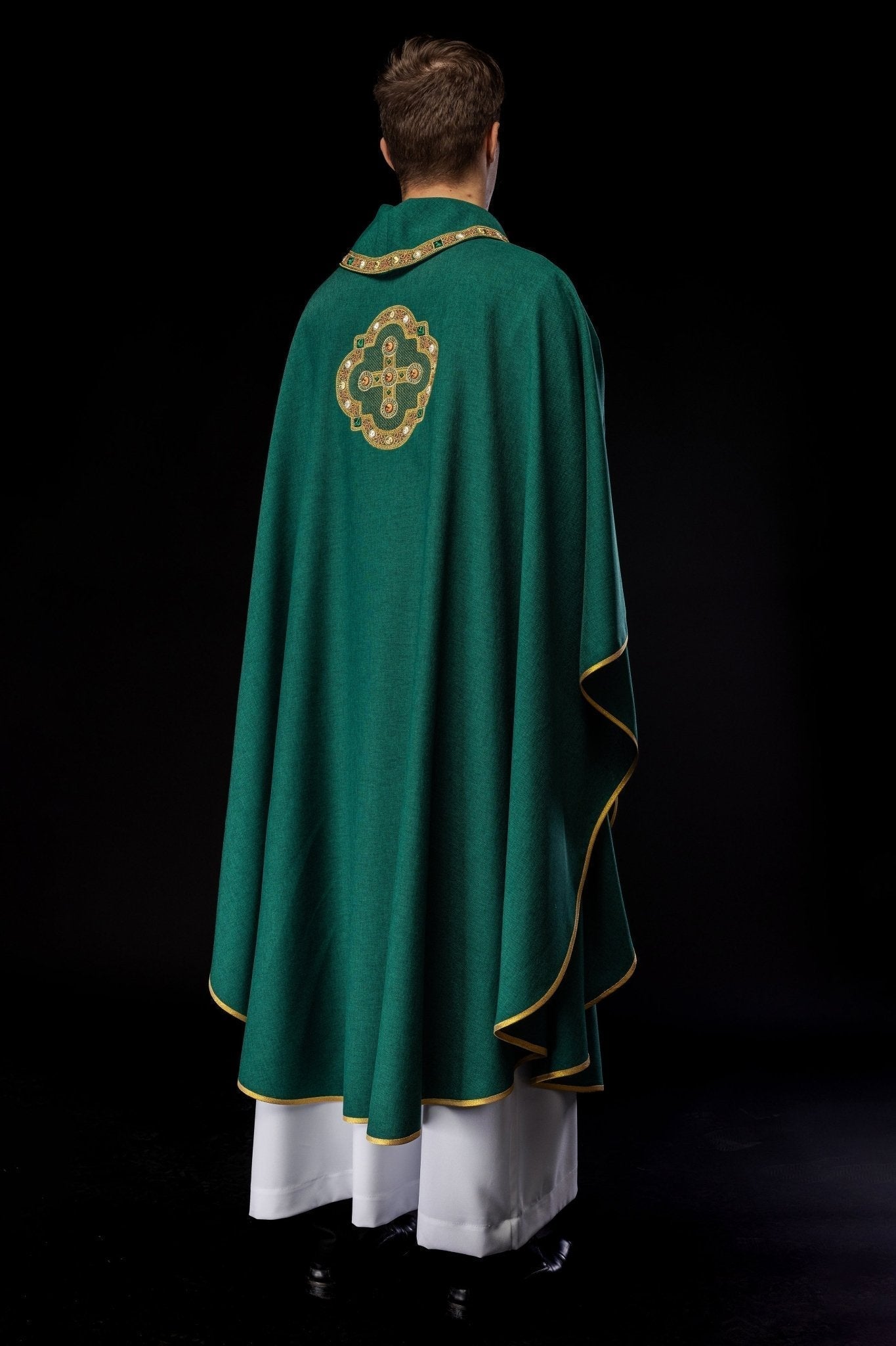 Casulla de color verde con ribetes bordados en el cuello y alrededor del bordado de la cruz