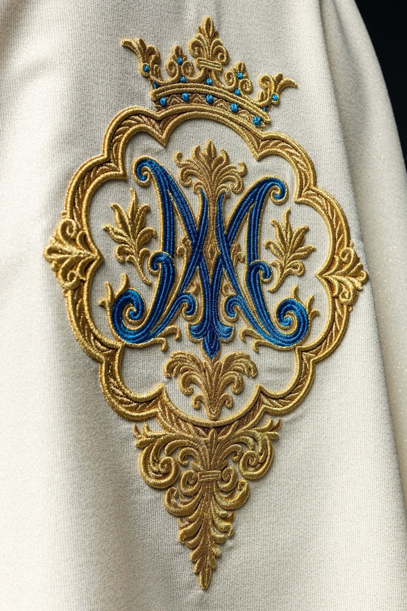 Casulla litúrgico con escudo bordado de María y corona