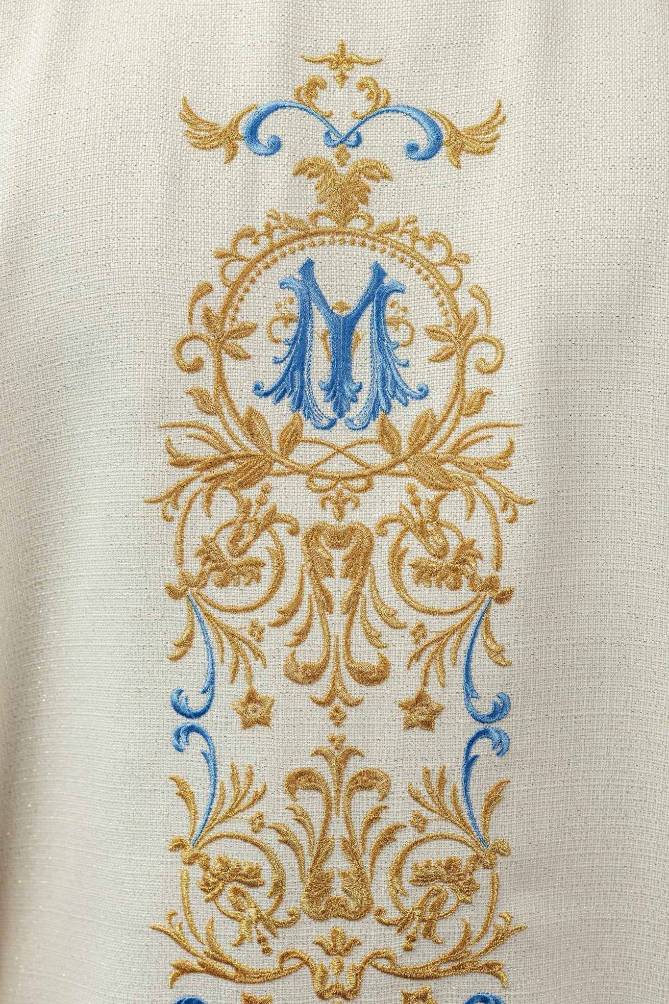 Casulla mariana marfil, ricamente bordada, de tela brillante.