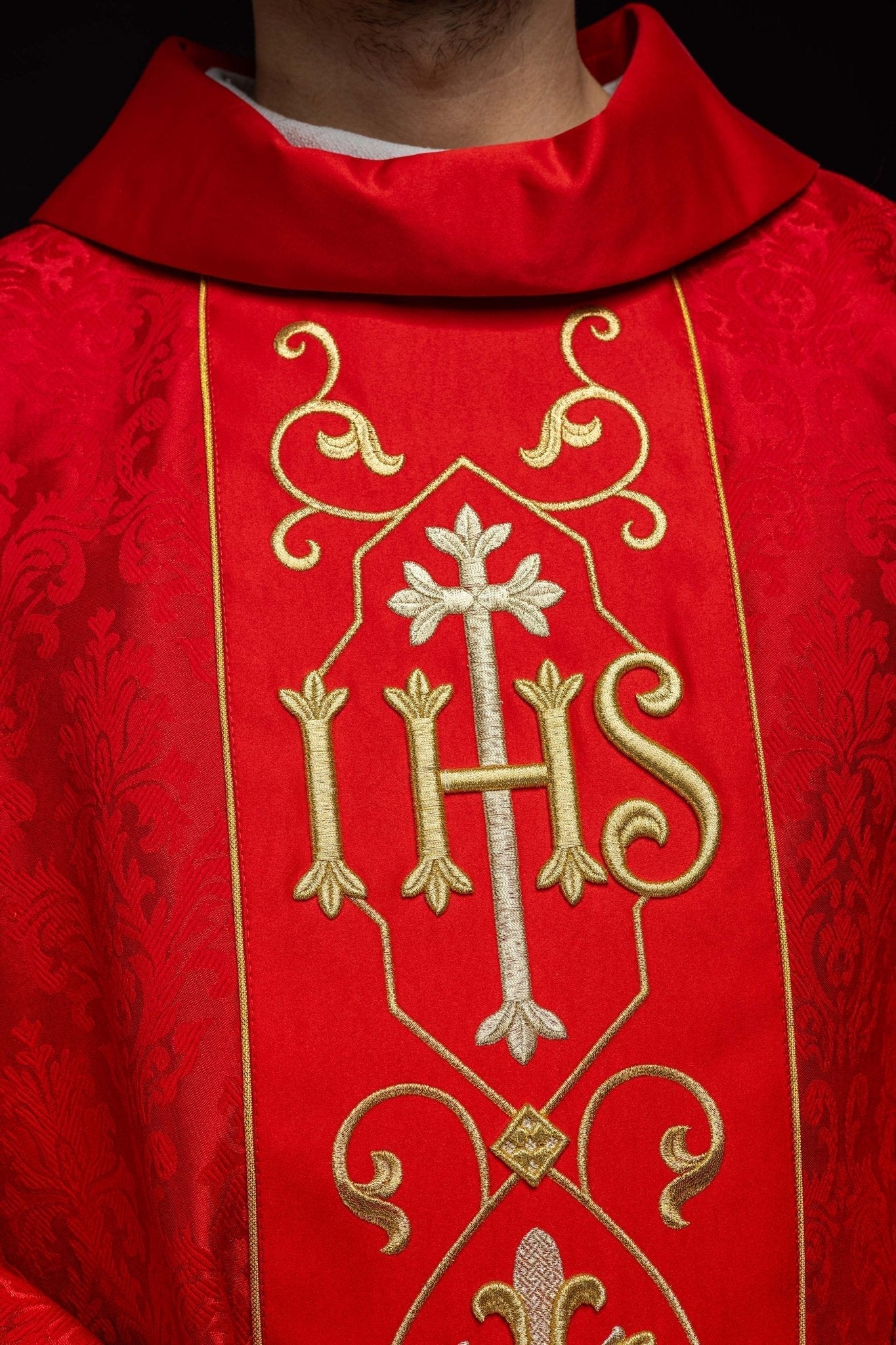 Casulla roja con bordado IHS ; la tela decorativa