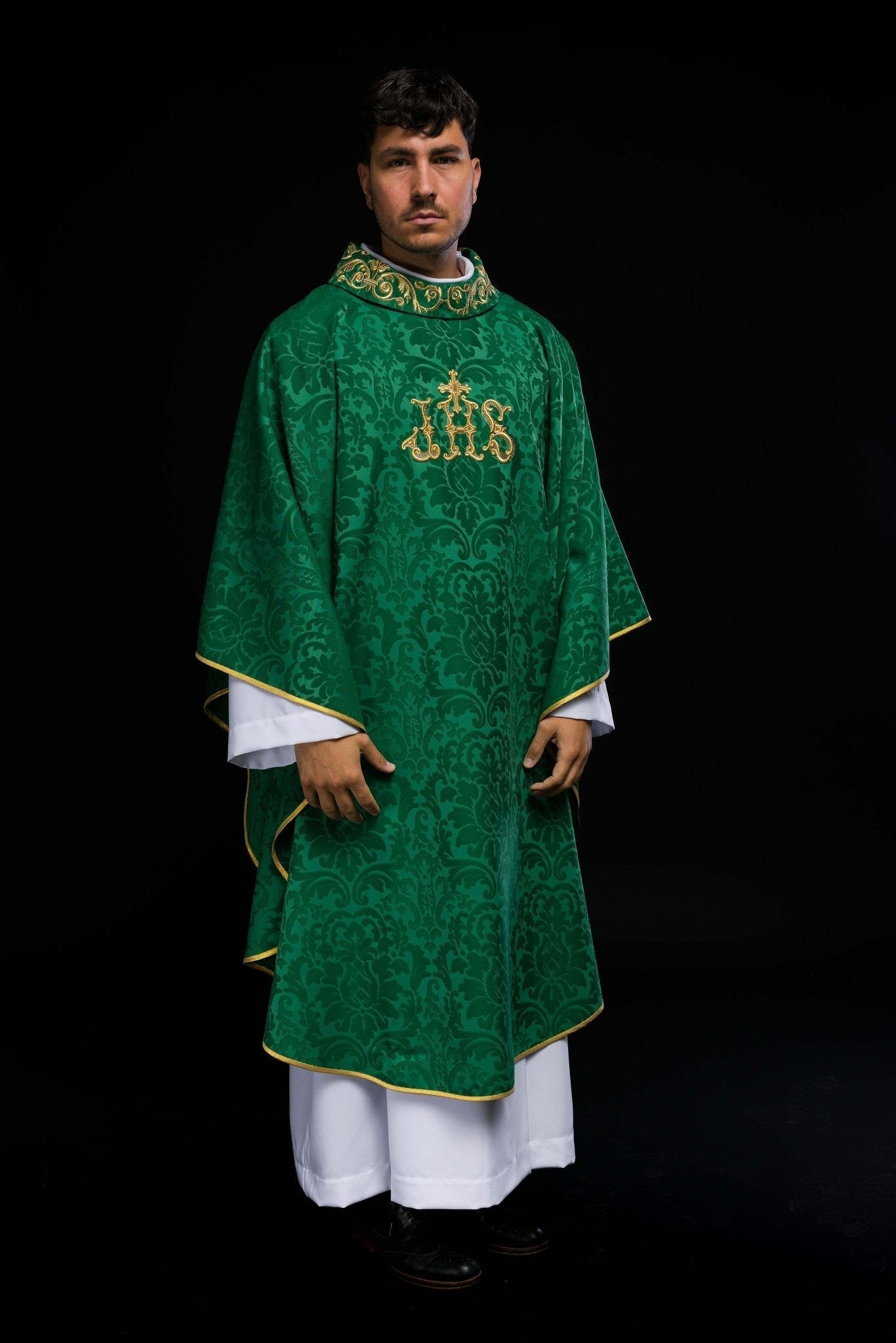 Casulla verde con motivo IHS y cuello ricamente bordado sobre tela decorativa