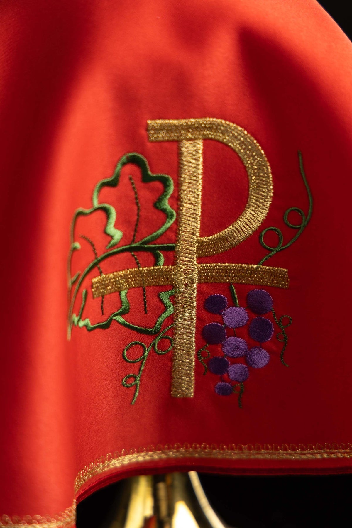 Velo para copón rojo, detalle del bordado PAX dorado con hojas y uvas