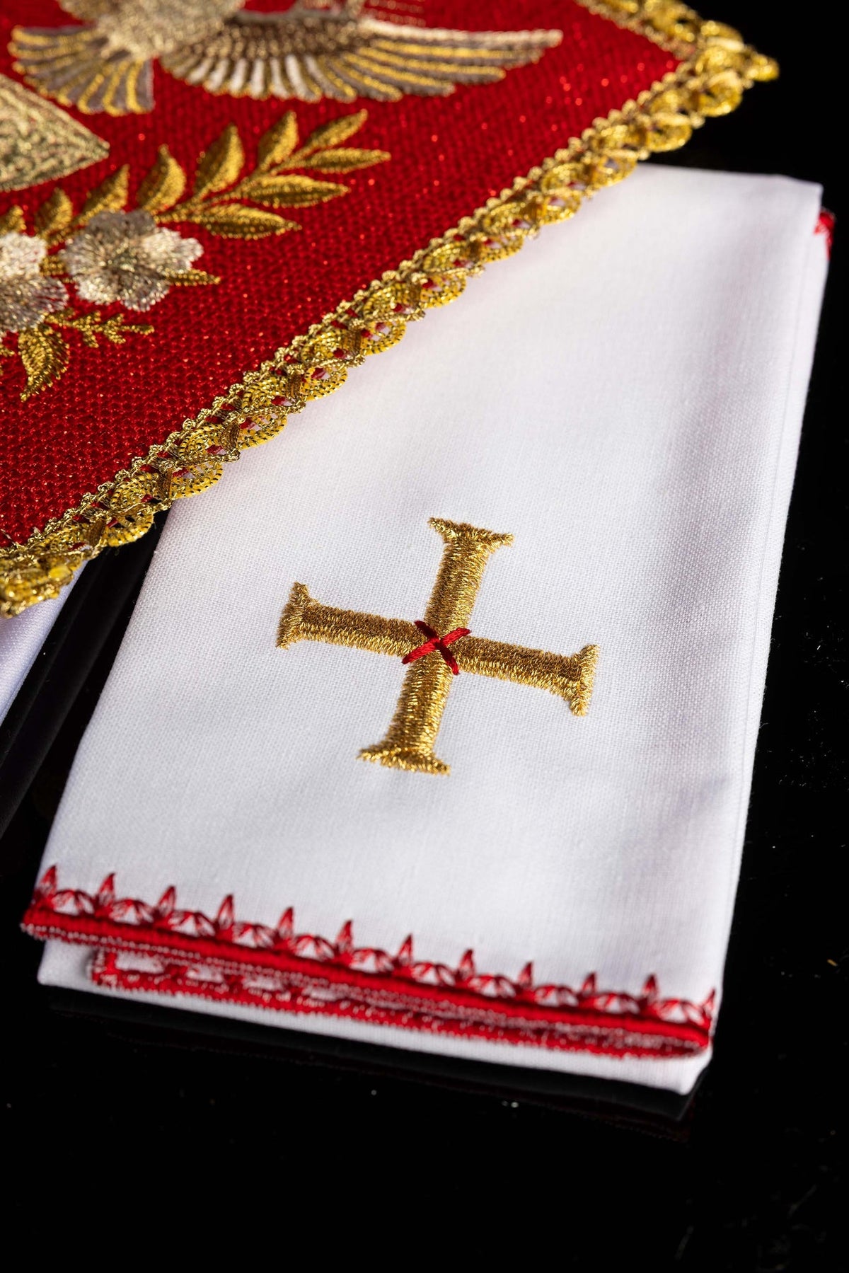 Juego de altar con cruz dorada bordada sobre pieza blanca con borde rojo